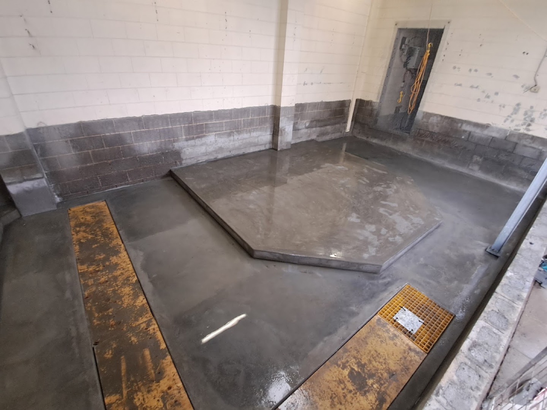 An interior blockwork room with formed concrete work set into the floor