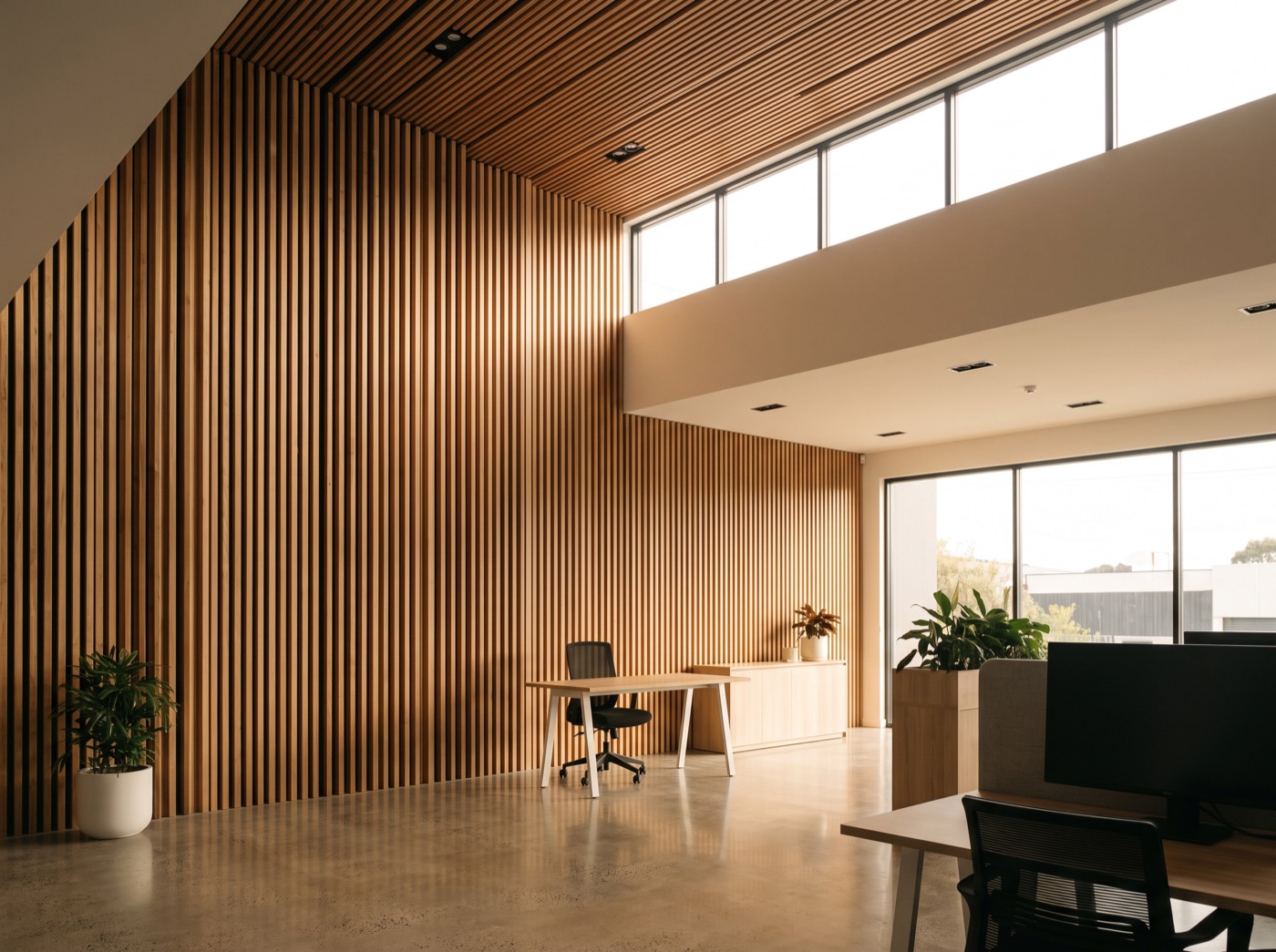 A commercial interior with a vertical timber batten wall meeting a slatted timber ceiling