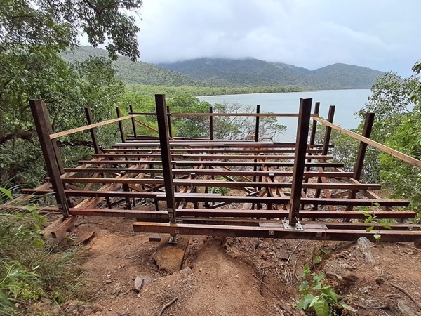 A timber and steel deck frame on a headland above the water